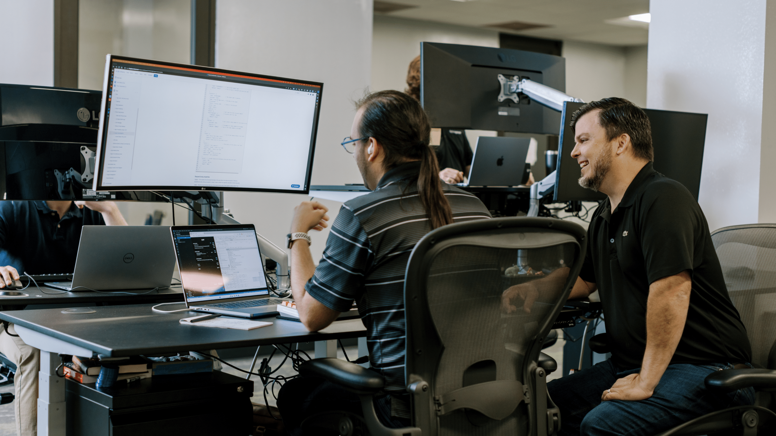 Two software developers collaborating on a project at a desk.